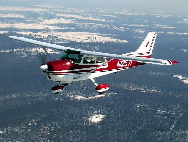 Cessna flying over a winter landscape